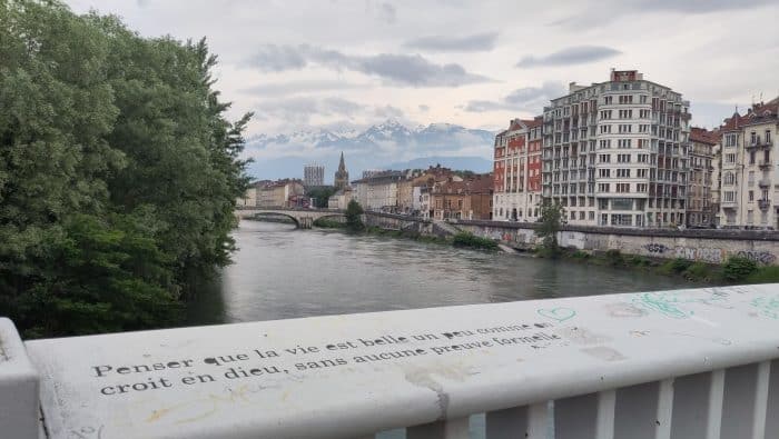 Pont à Grenoble, sur lequel est tagué "Penser que la vie est belle un peu comme on croit en Dieu, sans aucune preuve formelle"