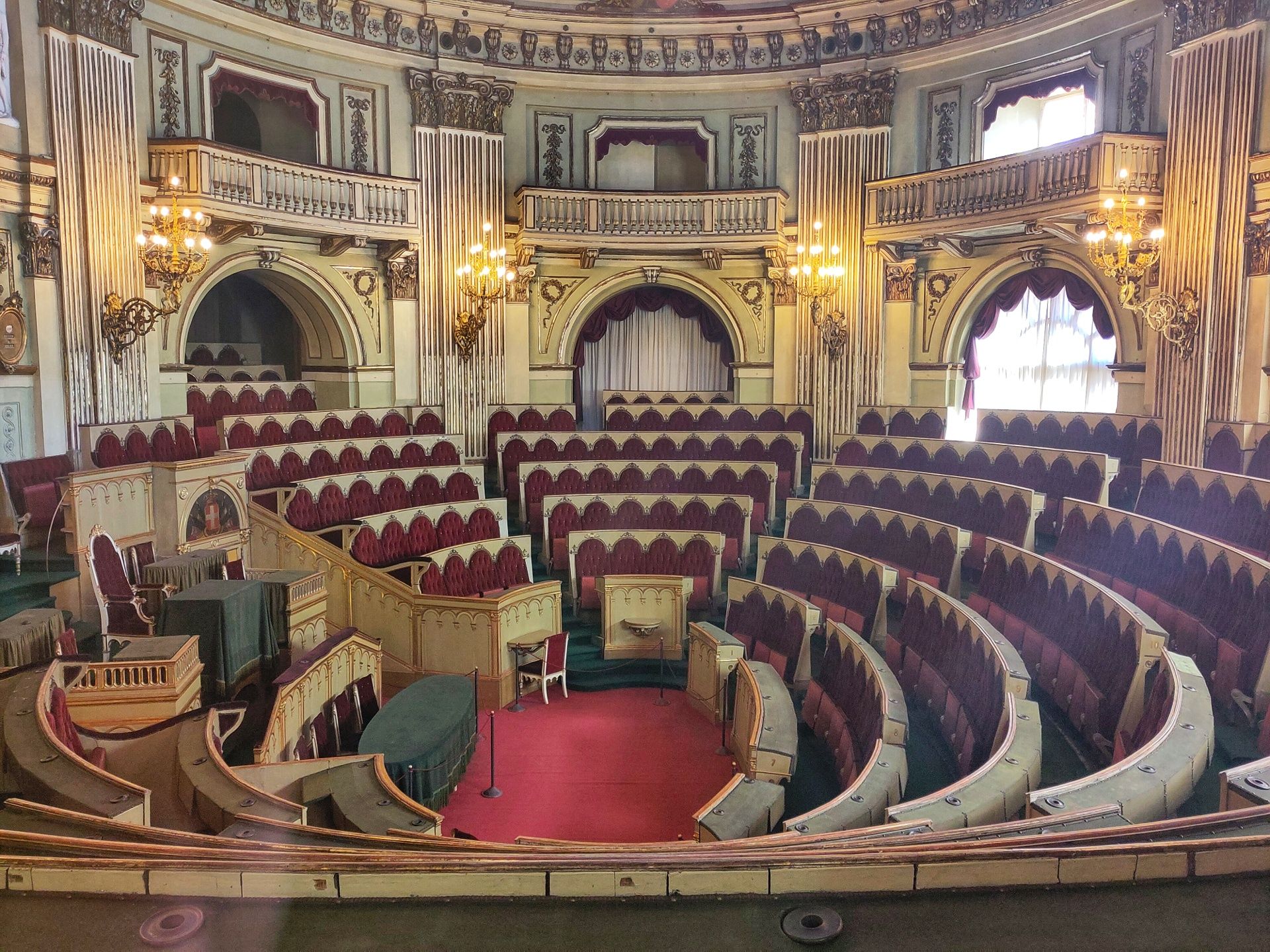 A hemicycle with red velvet seats.