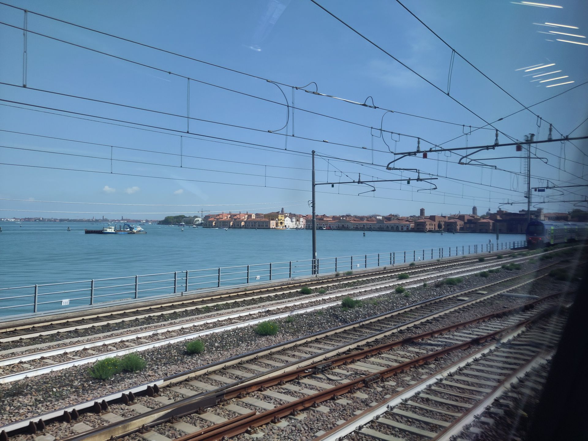 Venice laguna when coming by train, with the tracks close to me and buildings far away on the shore.