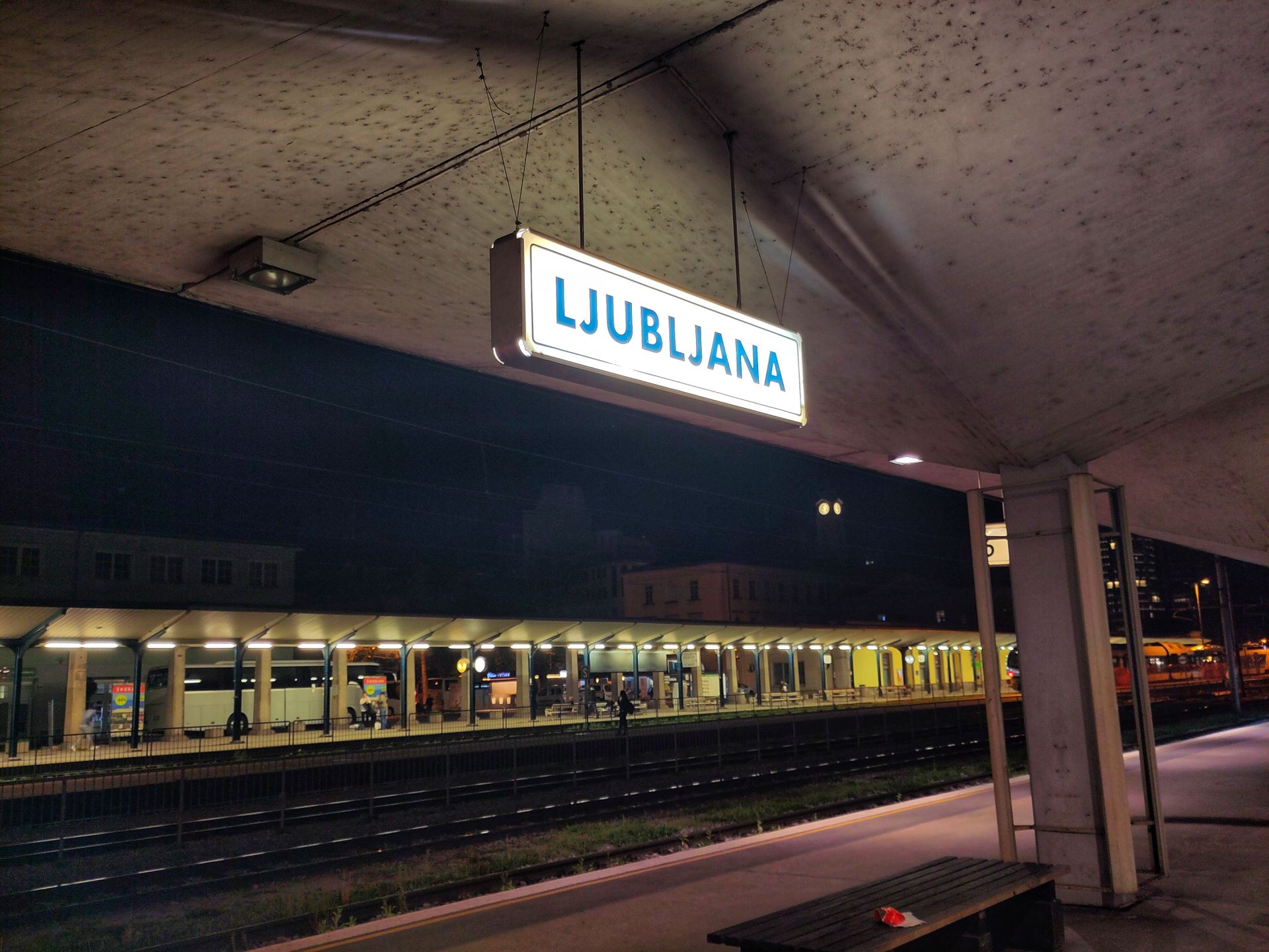 By night, the Ljubljana train station sign on a quay.