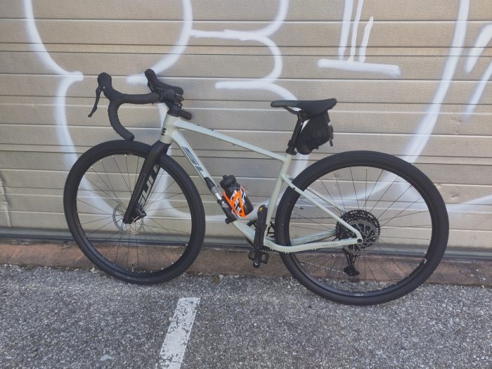 mon superbe vélo, un gravel gris avec un porte-bidon orange fluo