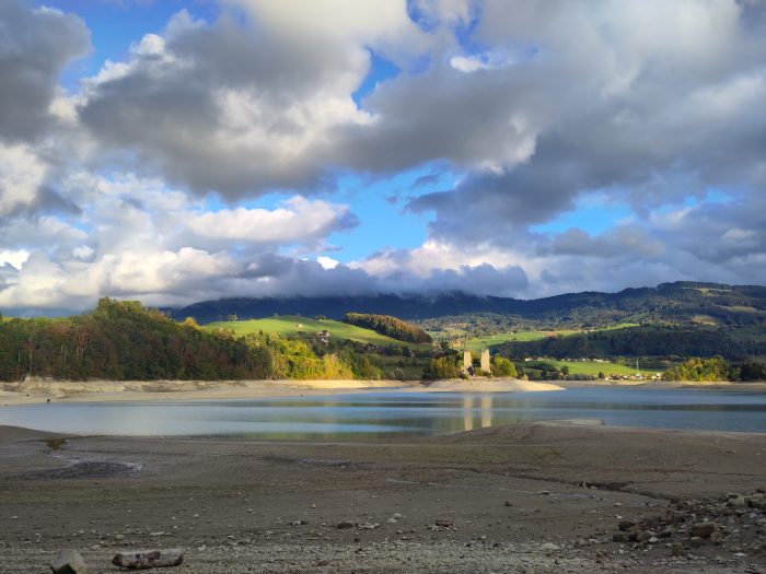 Un très joli lac avec un petit château en ruine sur une île au milieu.